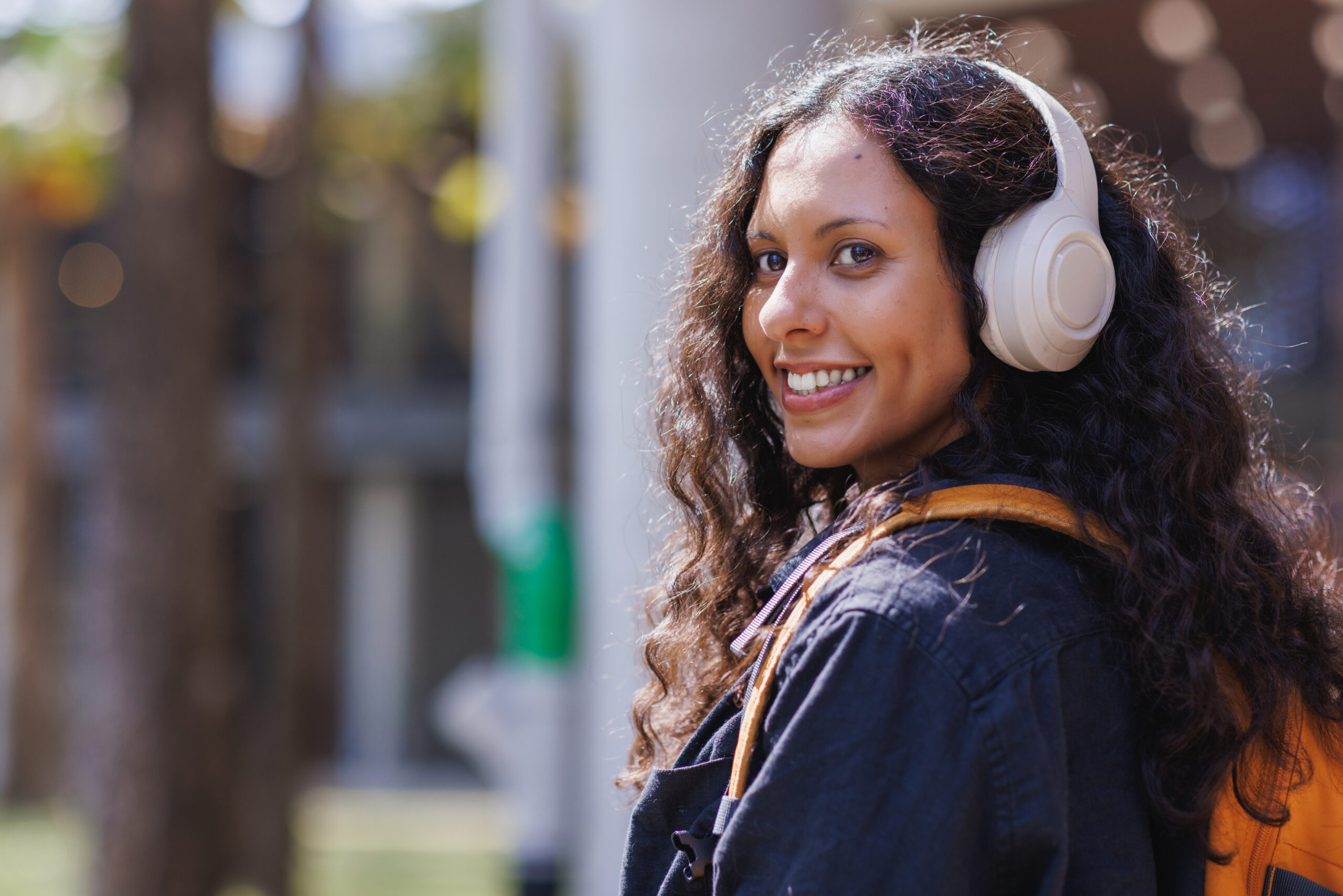 Young woman smiling listening to music with headphones